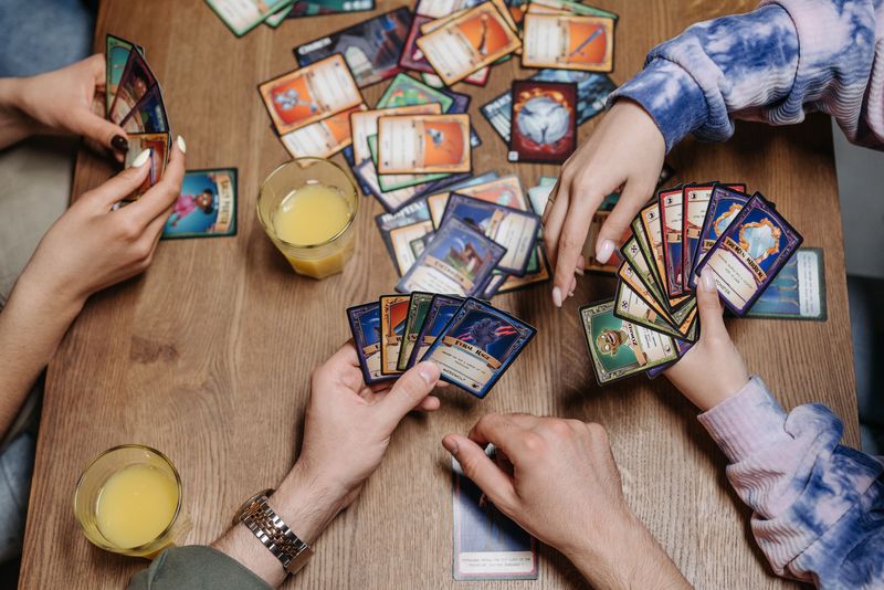 Three friends gathered around a table playing a card game, illustrating the social partnership at the heart of Guandan
