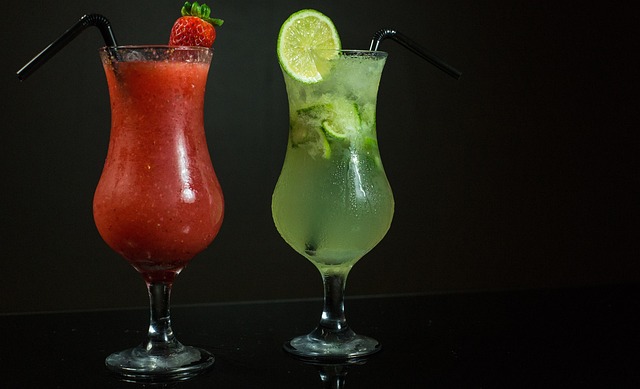 Multiple colorful cocktail glasses lined up on a dark surface, showing the variety of drinks possible with basic ingredients