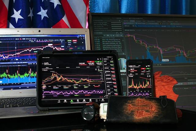 Stock market trading floor with digital screens showing live market data