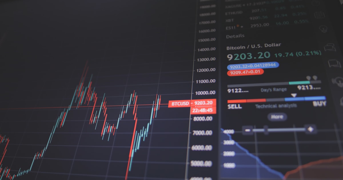 Financial analysts reviewing stock charts and data on screens in a modern office