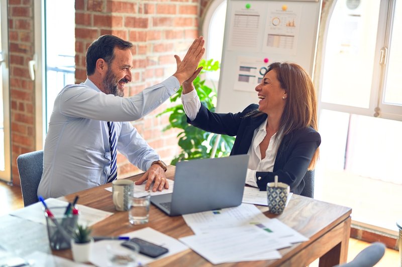 Two people meeting at a desk in an office, representing the business negotiation dynamics between buyers, sellers, and agents in Shanghai's second-hand property market