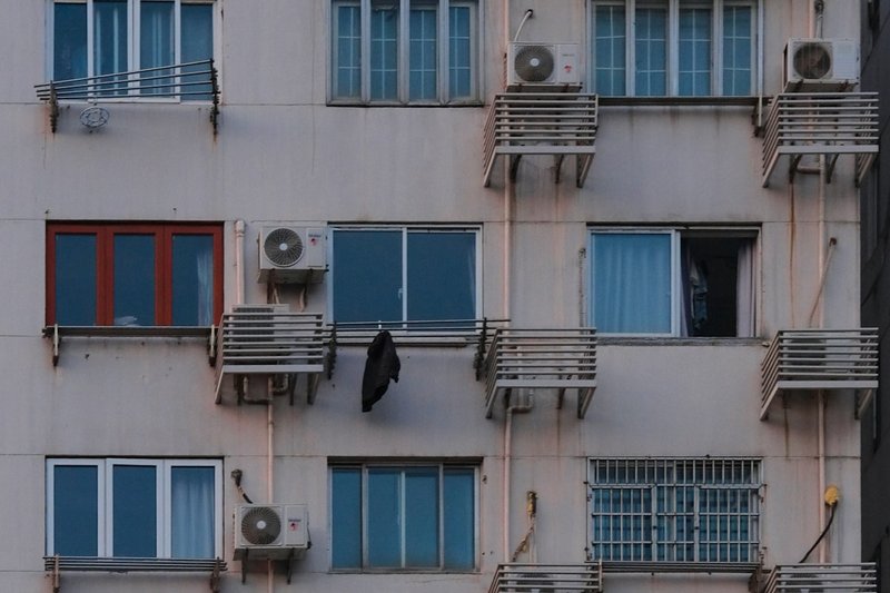 Old Shanghai apartment building facade with numerous windows and air conditioners, representing typical second-hand home stock in the city's residential neighborhoods