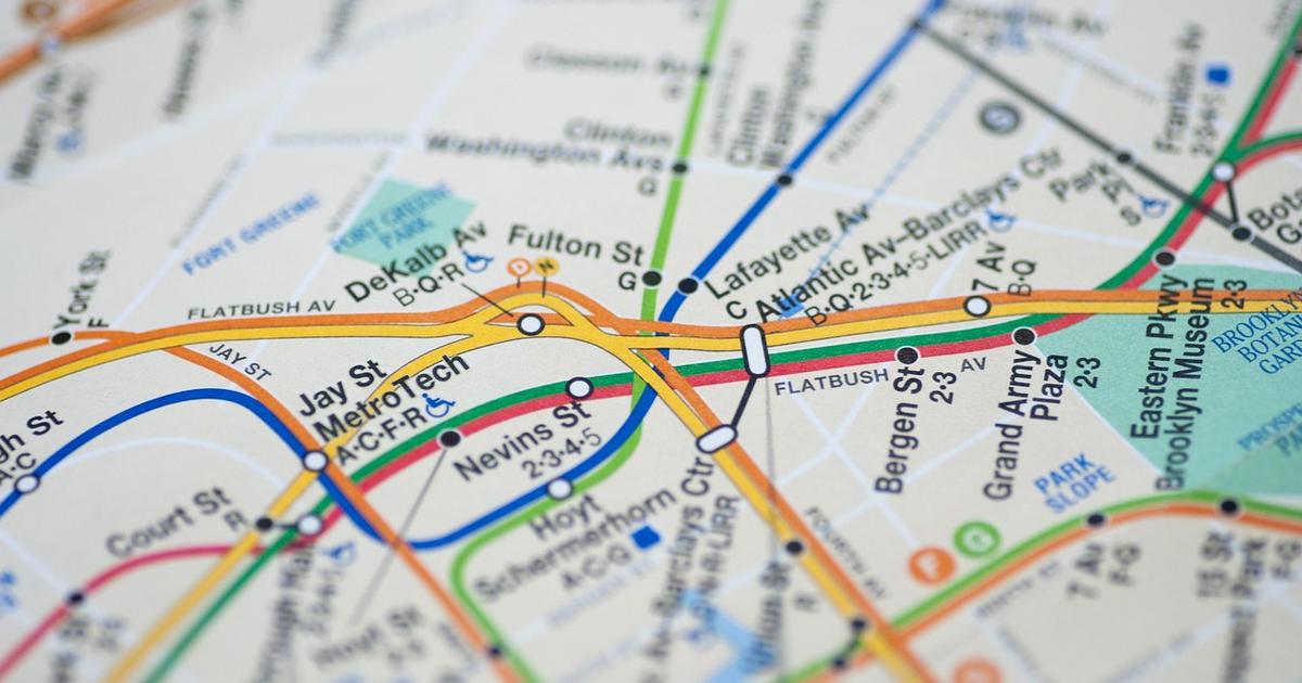 A close-up of a printed subway map with orange, blue, green and red lines crossing at interchange stations, illustrating the metro-map metaphor used to draw 447 Shanhaijing mountains