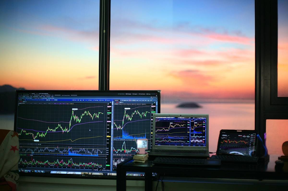 A modern stock market trading screen showing candlestick charts and financial data, representing the intersection of technology and value investing