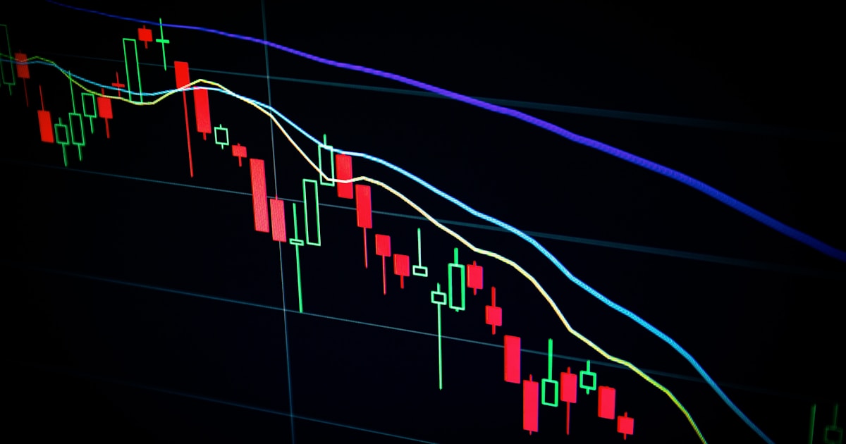 Stock market candlestick chart on dark screen showing financial data and trading patterns